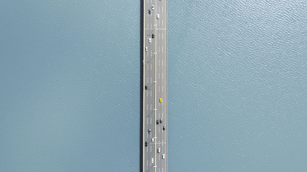 A birds eye view of a road with multiple cars driving across
