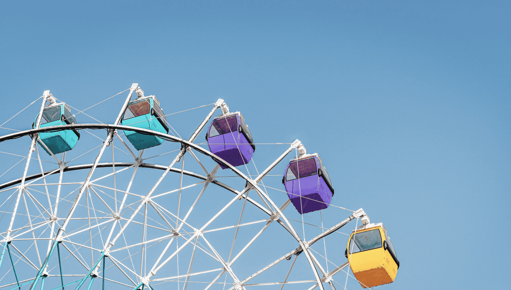 Top corner of a ferris wheel against a blue sky.