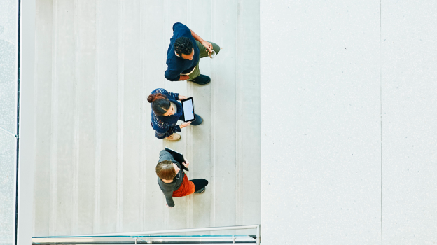 View from above of three people walking up some stairs.